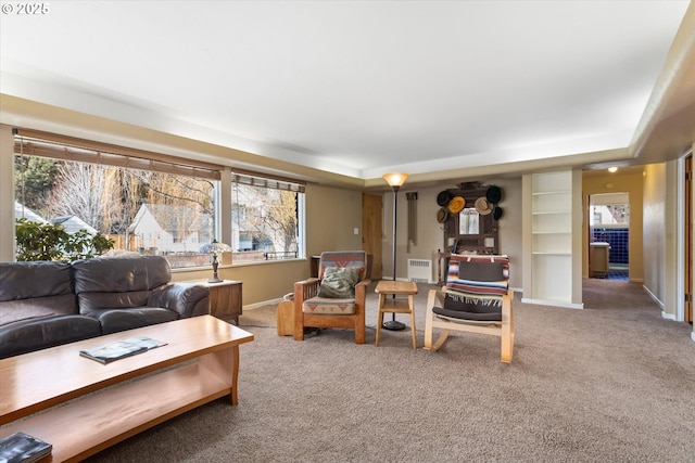 living room featuring plenty of natural light, carpet flooring, and a raised ceiling