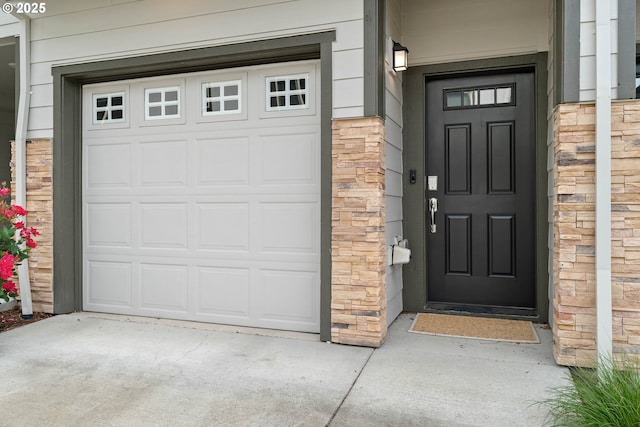 10420 SW Akilean Ter, Portland, OR 97223 - view of exterior entry with a garage, driveway, and stone siding