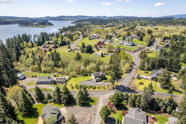 birds eye view of property with a forest view, a water view, and a residential view
