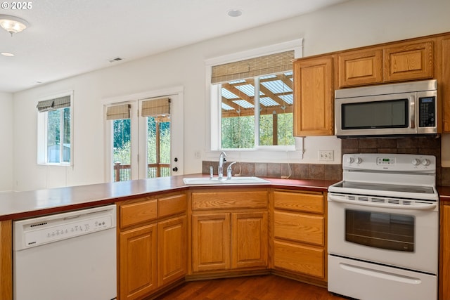 kitchen featuring a wealth of natural light, visible vents, a sink, and white appliances