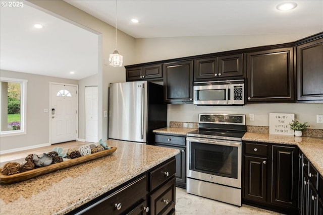 kitchen featuring recessed lighting, light stone counters, vaulted ceiling, and stainless steel appliances