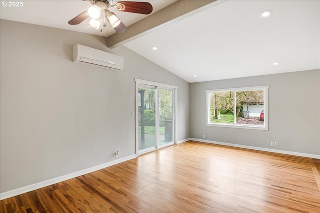 empty room featuring baseboards, a wall unit AC, lofted ceiling with beams, and wood finished floors