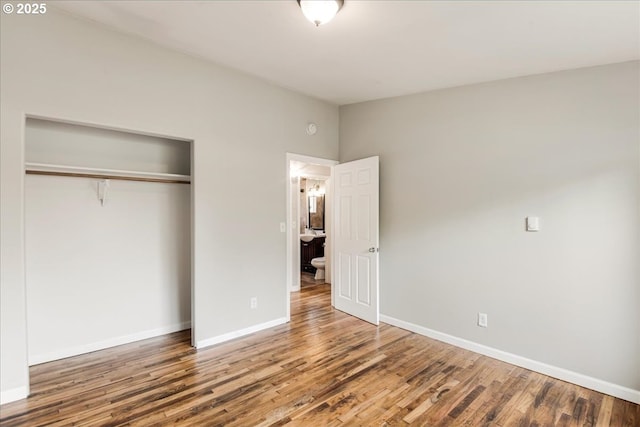 unfurnished bedroom featuring a closet, baseboards, and wood finished floors