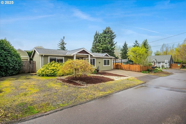 ranch-style home with driveway and fence