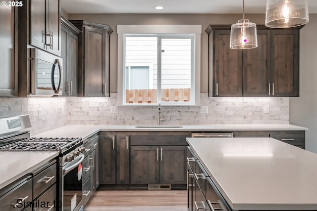 458 NE Cedar St, Sublimity, OR 97385 - kitchen featuring appliances with stainless steel finishes, a sink, light wood-style flooring, dark brown cabinets, and recessed lighting