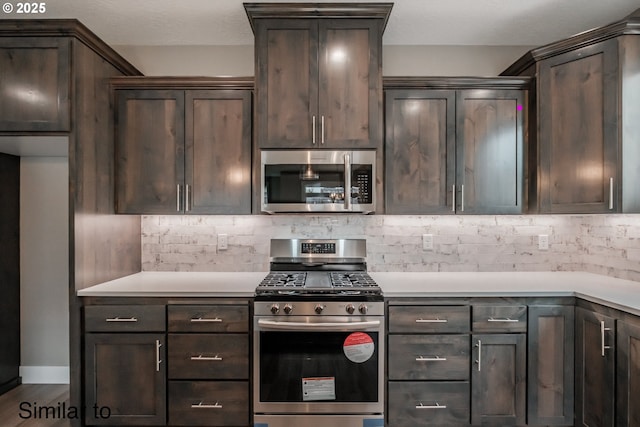 458 NE Cedar St, Sublimity, OR 97385 - kitchen with appliances with stainless steel finishes, dark brown cabinetry, backsplash, and light countertops