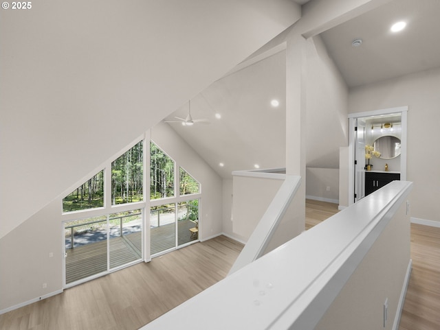 corridor with baseboards, recessed lighting, an upstairs landing, wood finished floors, and high vaulted ceiling