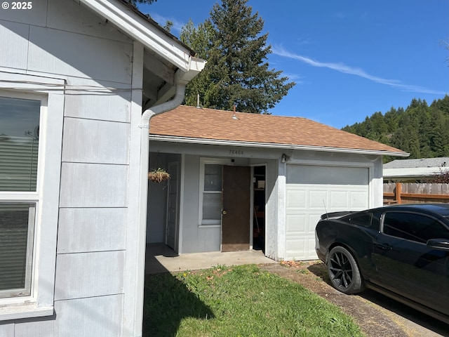 76464 High St, Oakridge, OR 97463 - view of side of home with a garage, a shingled roof, and fence