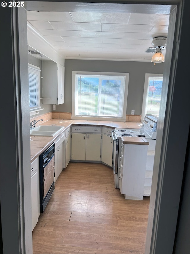 76464 High St, Oakridge, OR 97463 - kitchen with white electric range, a sink, black dishwasher, light countertops, and light wood-style flooring