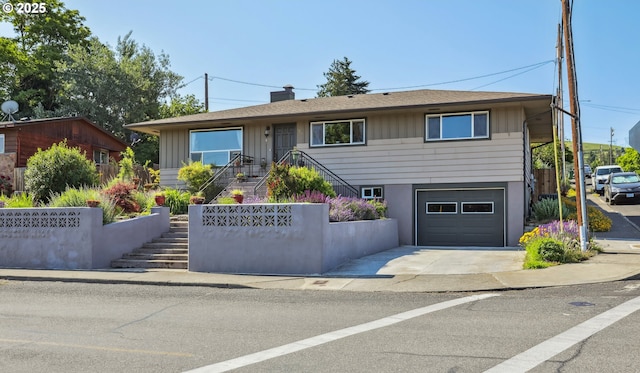 1900 E 10th St, The Dalles, OR 97058 - view of front facade with an attached garage, stairway, concrete driveway, and board and batten siding