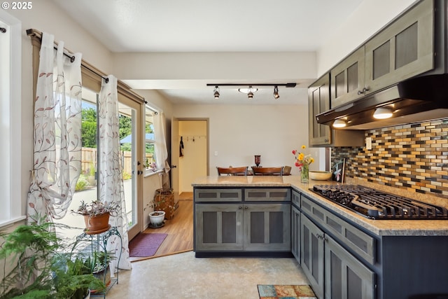 1900 E 10th St, The Dalles, OR 97058 - kitchen with a peninsula, gray cabinets, black gas cooktop, extractor fan, and backsplash