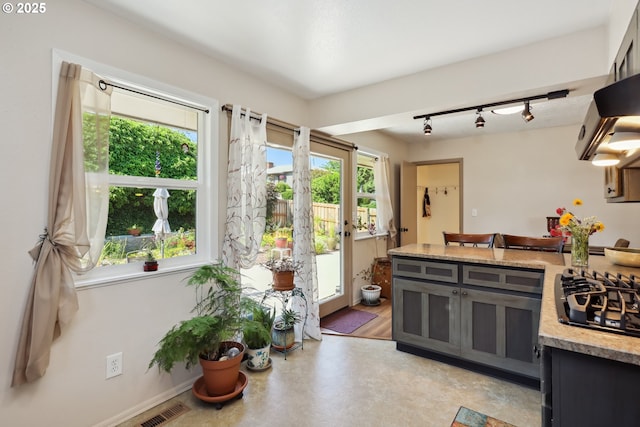 1900 E 10th St, The Dalles, OR 97058 - kitchen with black gas cooktop, plenty of natural light, light countertops, and track lighting