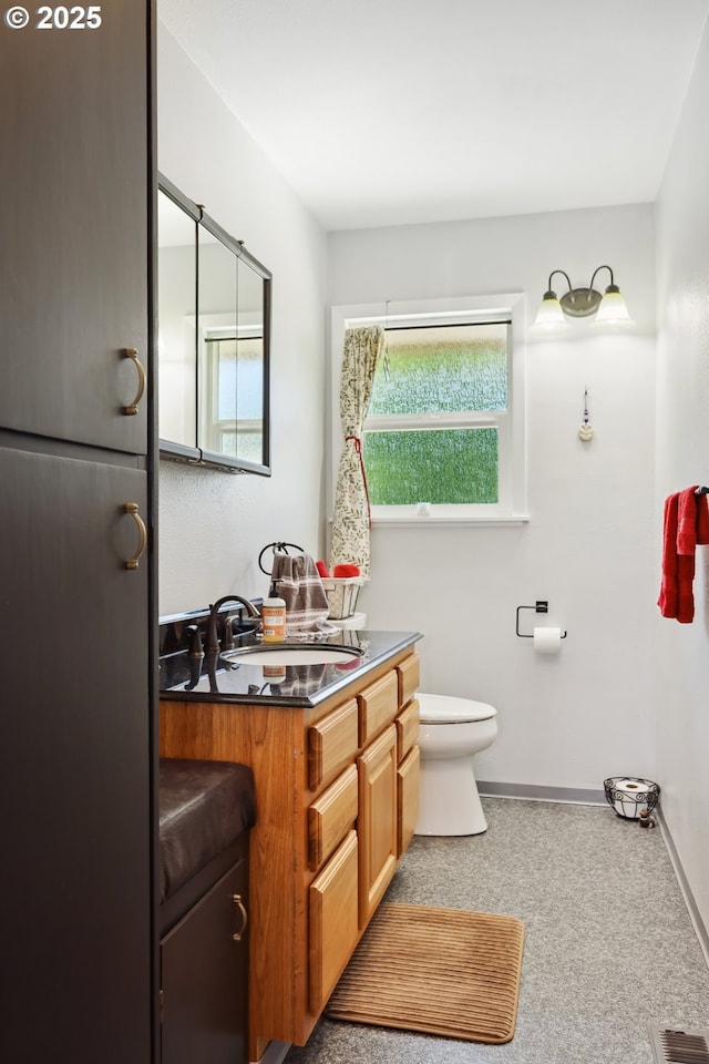 1900 E 10th St, The Dalles, OR 97058 - bathroom with vanity, toilet, and baseboards