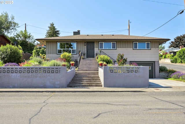 1900 E 10th St, The Dalles, OR 97058 - view of front facade featuring driveway, stairway, an attached garage, board and batten siding, and a chimney
