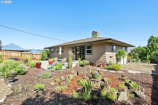 1900 E 10th St, The Dalles, OR 97058 - rear view of house with a patio, an attached garage, and a chimney