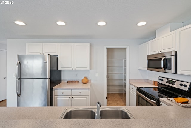 1608 NE 154th St, Vancouver, WA 98686 - kitchen featuring stainless steel appliances, a sink, white cabinetry, light countertops, and recessed lighting