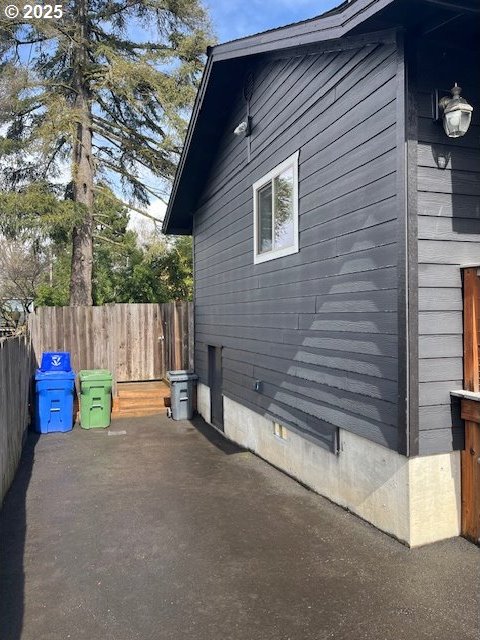 view of side of home with a patio area and fence