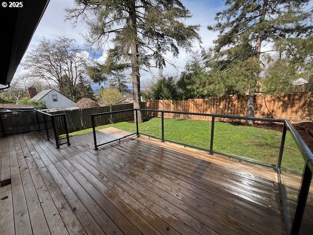 deck with a lawn and a fenced backyard