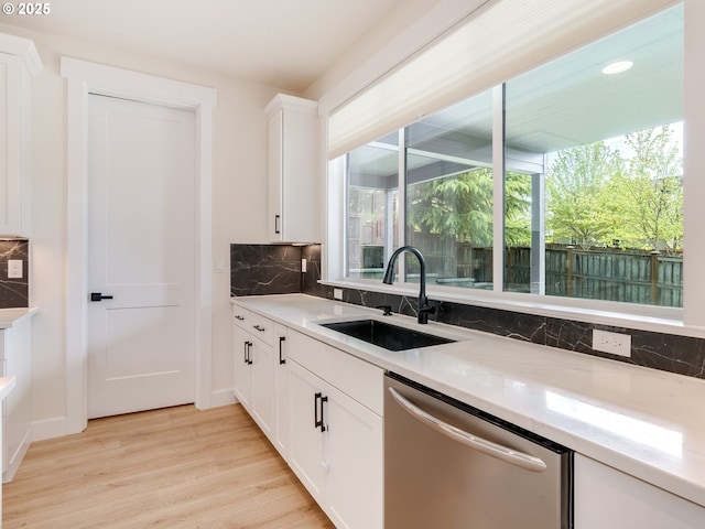 2650 NW Mt Ashland Dr, Mcminnville, OR 97128 - kitchen with a sink, stainless steel dishwasher, tasteful backsplash, light wood finished floors, and white cabinets