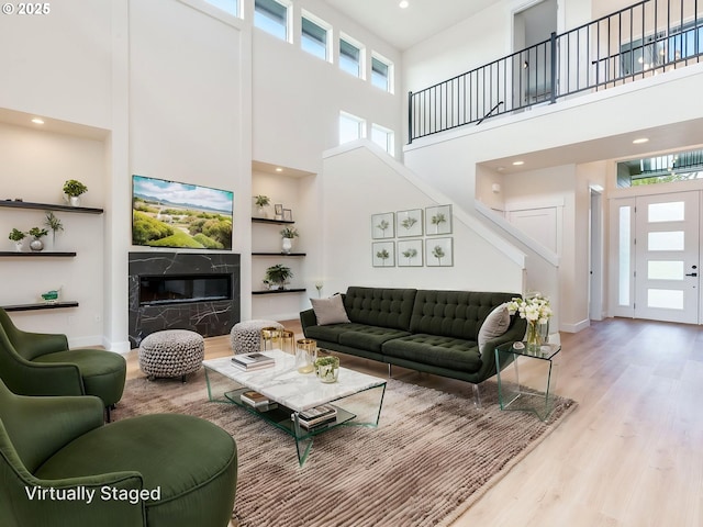 2650 NW Mt Ashland Dr, Mcminnville, OR 97128 - living room with a towering ceiling, wood finished floors, recessed lighting, a high end fireplace, and stairs