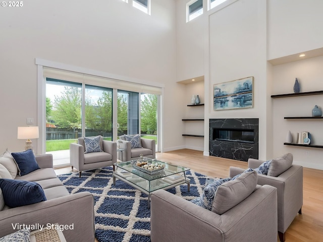 2650 NW Mt Ashland Dr, Mcminnville, OR 97128 - living room featuring a towering ceiling, healthy amount of natural light, wood finished floors, a fireplace, and baseboards