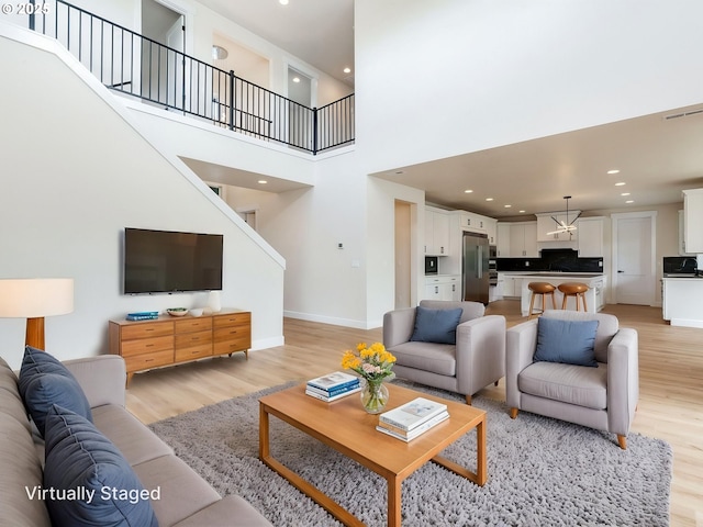 2650 NW Mt Ashland Dr, Mcminnville, OR 97128 - living area with light wood-style flooring, stairway, baseboards, recessed lighting, and a towering ceiling