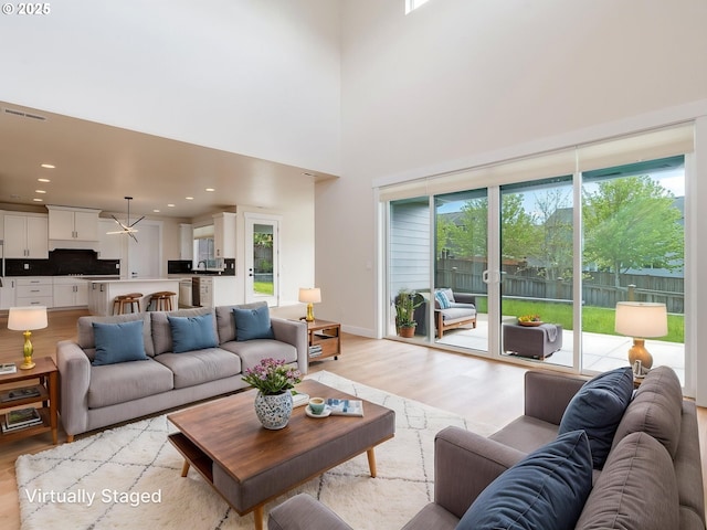 2650 NW Mt Ashland Dr, Mcminnville, OR 97128 - living room with light wood finished floors, a chandelier, recessed lighting, and a towering ceiling