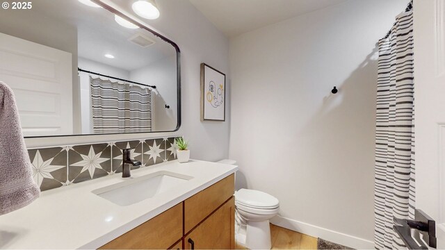 665 Browndell Ln, Stanfield, OR 97875 - full bath featuring vanity, toilet, decorative backsplash, baseboards, and wood finished floors