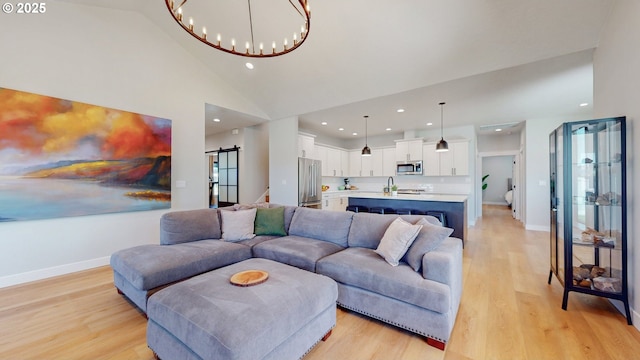 665 Browndell Ln, Stanfield, OR 97875 - living area with a barn door, light wood finished floors, a chandelier, recessed lighting, and high vaulted ceiling