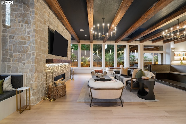 interior space featuring beam ceiling, a fireplace, a chandelier, and light hardwood / wood-style flooring