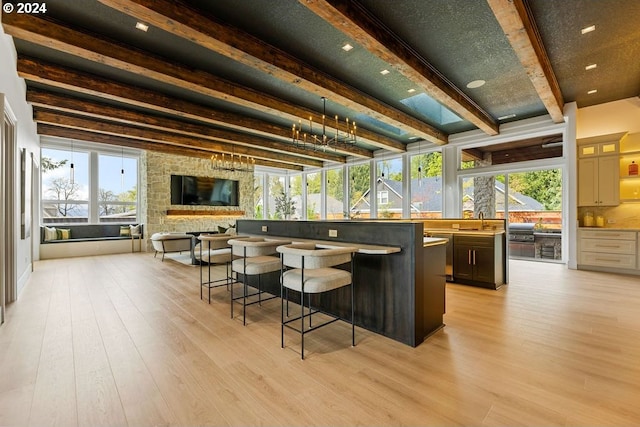 bar with sink, light hardwood / wood-style flooring, and beam ceiling