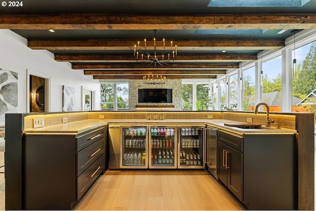 bar with sink, beverage cooler, beam ceiling, and light wood-type flooring