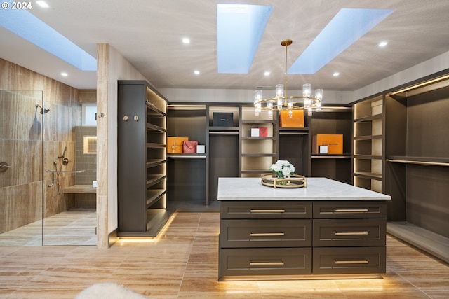 walk in closet featuring light tile patterned floors and a skylight