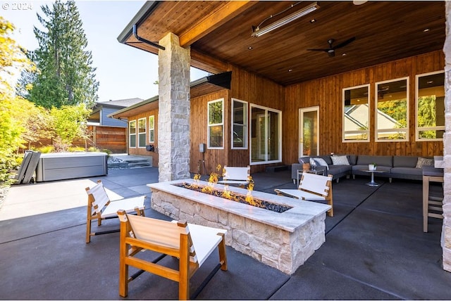 view of patio featuring ceiling fan and an outdoor living space with a fire pit