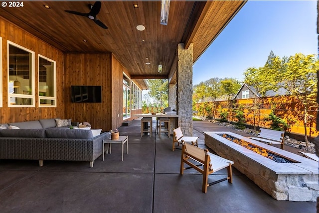 view of patio featuring ceiling fan and an outdoor living space with a fire pit