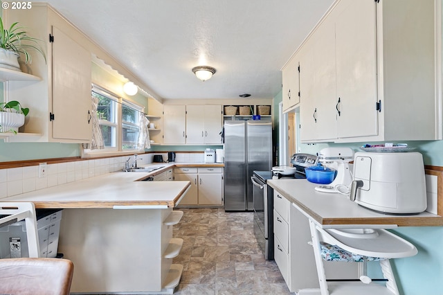 3505 Donald St, Eugene, OR 97405 - kitchen featuring open shelves, appliances with stainless steel finishes, light countertops, stone finish flooring, and a sink
