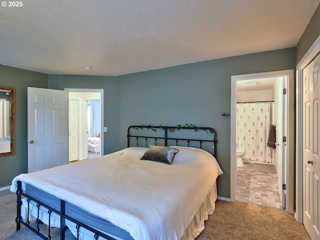 carpeted bedroom featuring ensuite bath, baseboards, and a textured ceiling