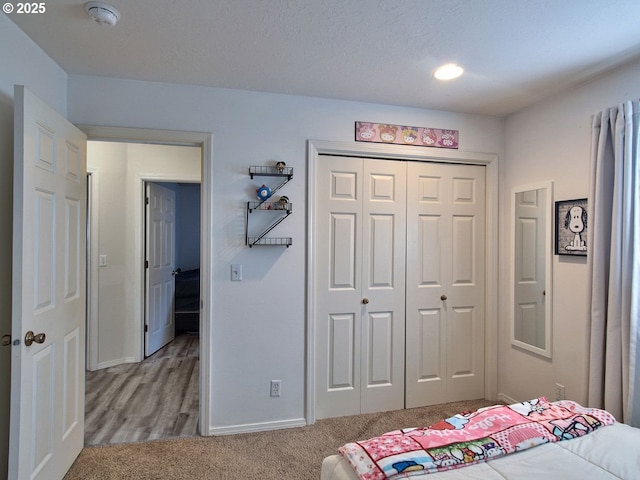 carpeted bedroom featuring a closet and baseboards