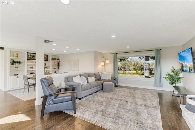 living area with visible vents, baseboards, recessed lighting, a textured ceiling, and wood-type flooring