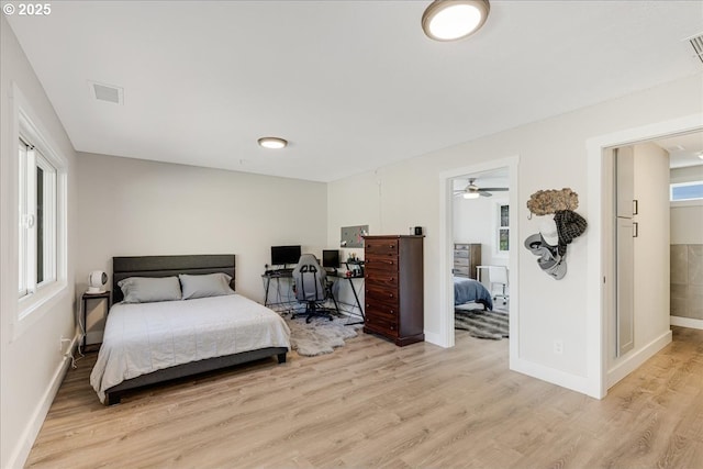 bedroom featuring visible vents, multiple windows, baseboards, and light wood-style flooring