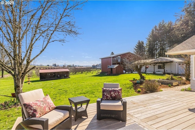 deck featuring a storage shed, an outbuilding, a garden, and a lawn