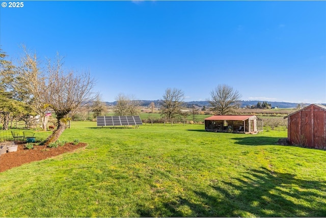 view of yard with an outbuilding and a rural view