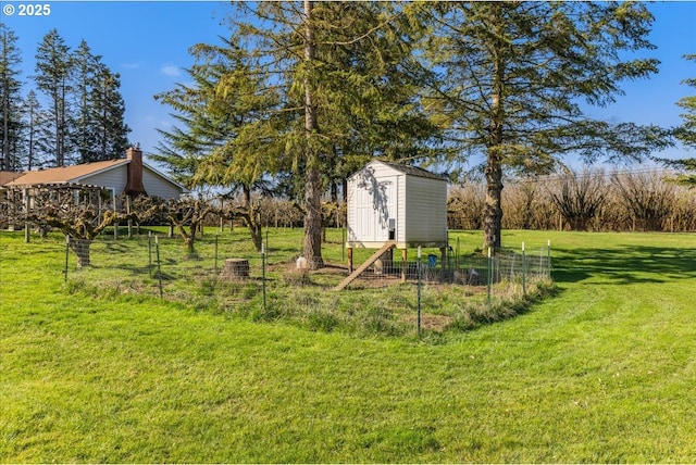 view of yard with an outbuilding, a storage shed, and fence