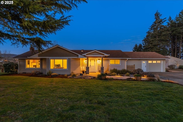 ranch-style house featuring a lawn, an attached garage, and driveway