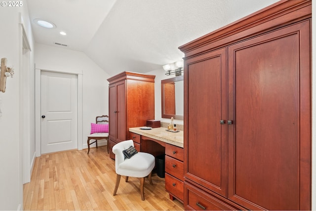 bathroom with vaulted ceiling, visible vents, recessed lighting, wood finished floors, and vanity