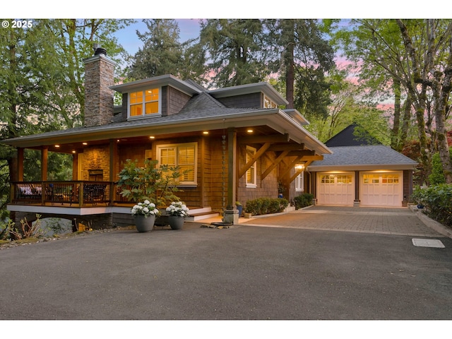 view of front of property with a chimney, roof with shingles, and a garage