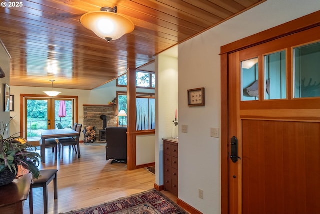 390 Singing Waters Rd, Winchester, OR 97495 - entryway with a wood stove, wooden ceiling, healthy amount of natural light, light wood-style flooring, and baseboards