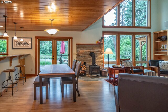 390 Singing Waters Rd, Winchester, OR 97495 - dining space with french doors, a wood stove, wooden ceiling, healthy amount of natural light, and light wood-style flooring