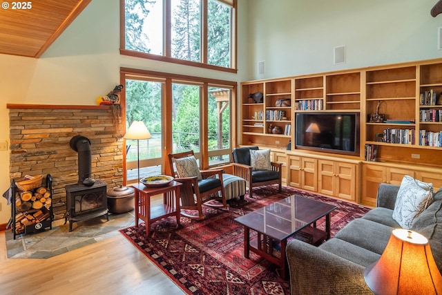 390 Singing Waters Rd, Winchester, OR 97495 - living room with high vaulted ceiling, plenty of natural light, wood finished floors, a wood stove, and wooden ceiling