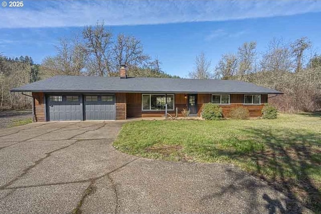 single story home with a garage, driveway, a front lawn, and a chimney